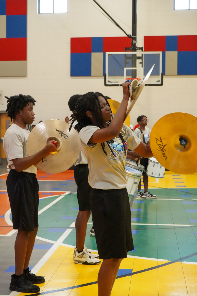 Center Point High School's drum line performs inside a school gym. They play the symbols and drums.