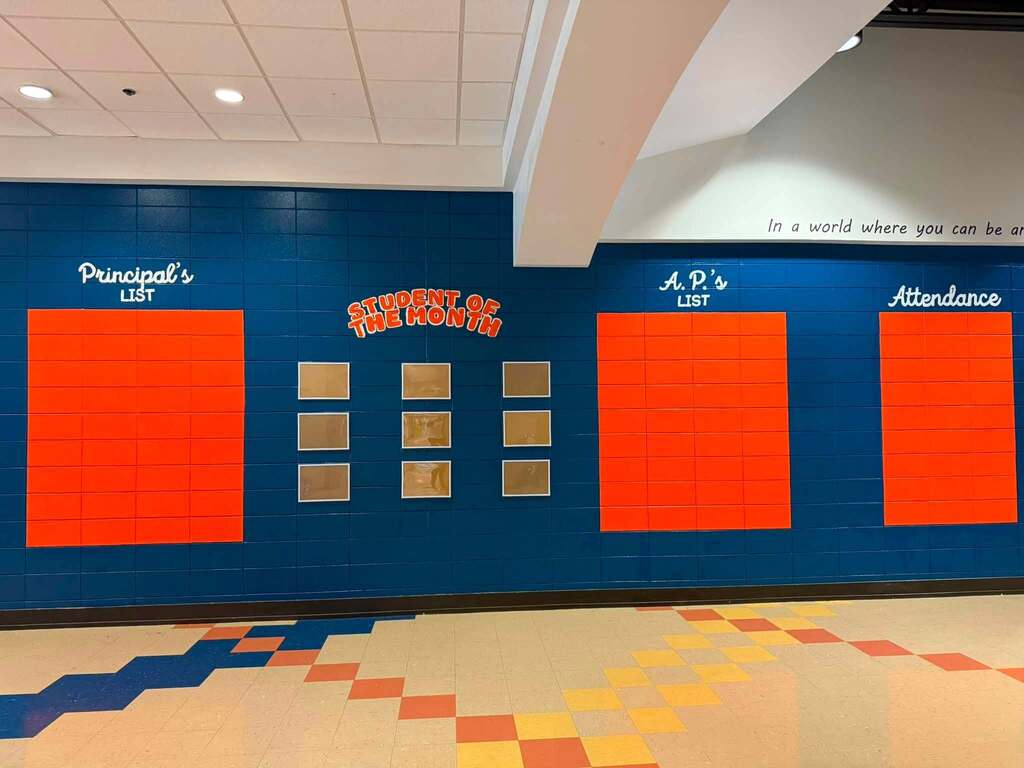 A colorful painting on the walls of a Fultondale Elementary School hallway. Paint spells out "Principal's list," "Student of the Month," "AP's list," and "Attendance." There's room underneath the words for students' names to go.
