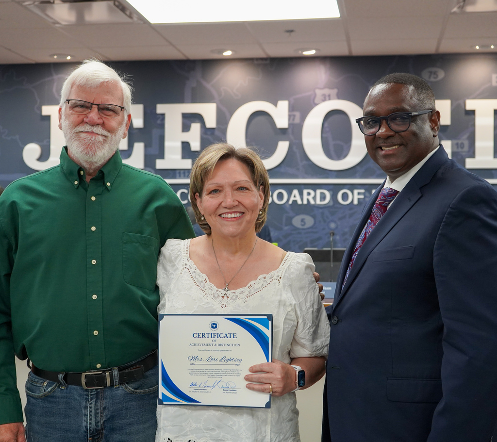 Retired JCIB principal Lori Lightsey poses for a photo with a man and JEFCOED superintendent Dr. Walter Gonsoulin inside the JEFCOED board room.