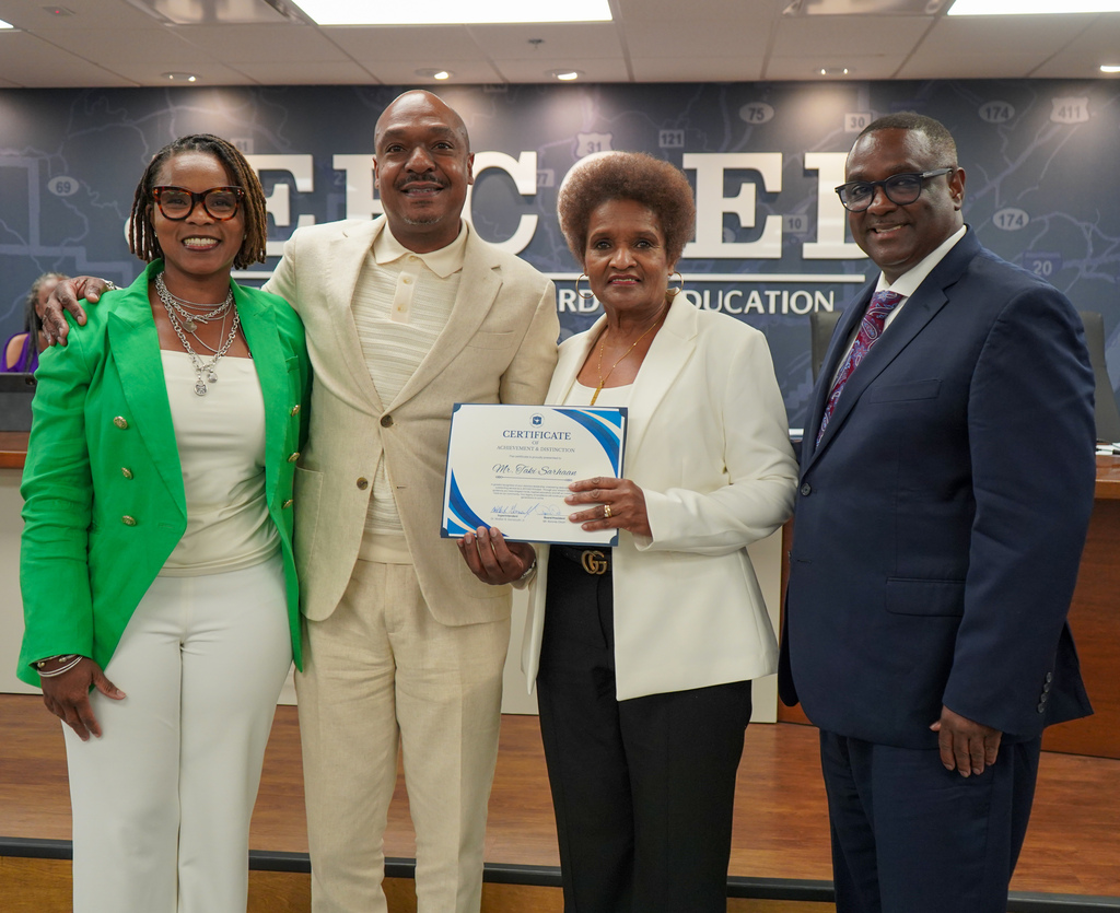 Retired Shades Valley High School principal Mr. Taki Sarhaan poses for a photo with his family and JEFCOED Superintendent Dr. Walter Gonsoulin inside the JEFCOED board room.