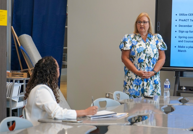 A woman addresses a room of administrators  