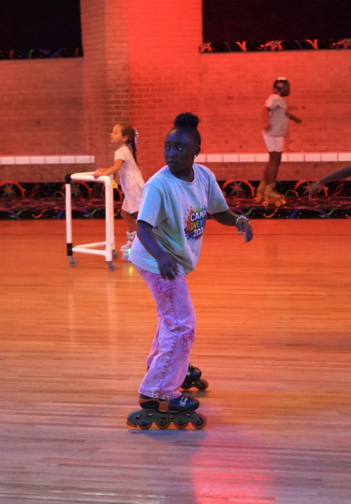 A girl skates backwards at a skating rink