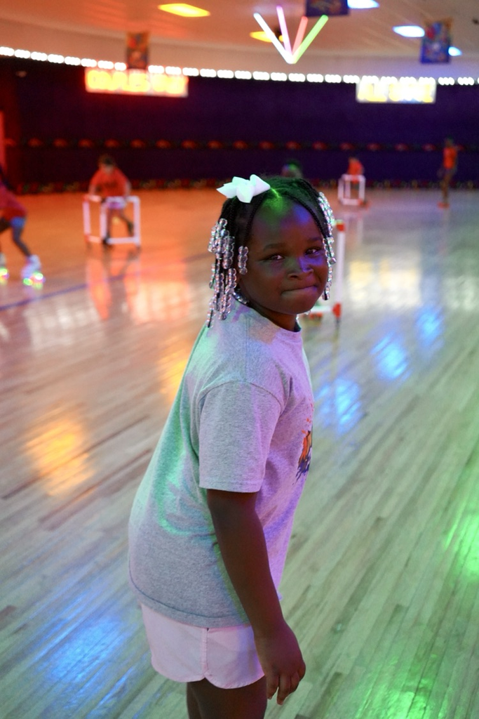 A girl smiles while skating at a skating rink