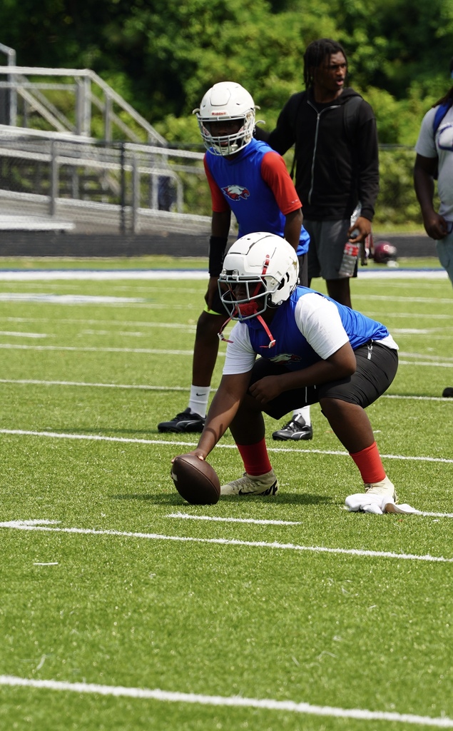 An Erwin Middle School football player prepares to snap a football during a game.