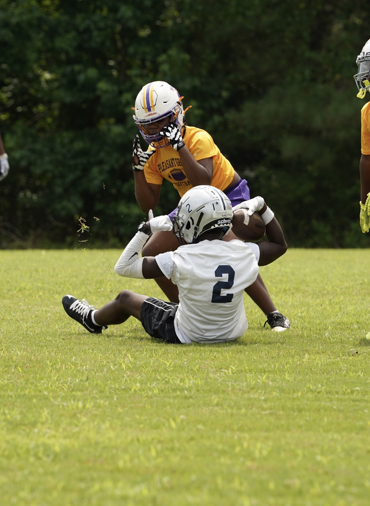 A Clay-Chalkville Middle School football player sits on the field and flexes after a play during a game.