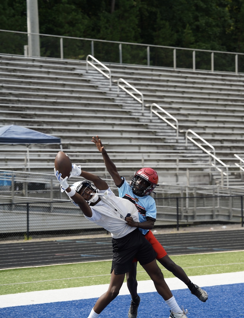 A Clay-Chalkville Middle School football player jumps to catch a football during a game as a player from the opposing team tries to tackle him.
