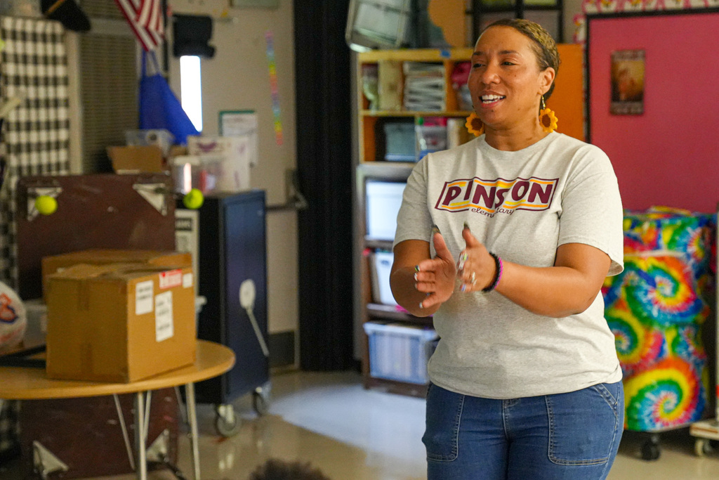 A Pinson Elementary School teacher claps her hands together while dancing to a song inside a classroom.