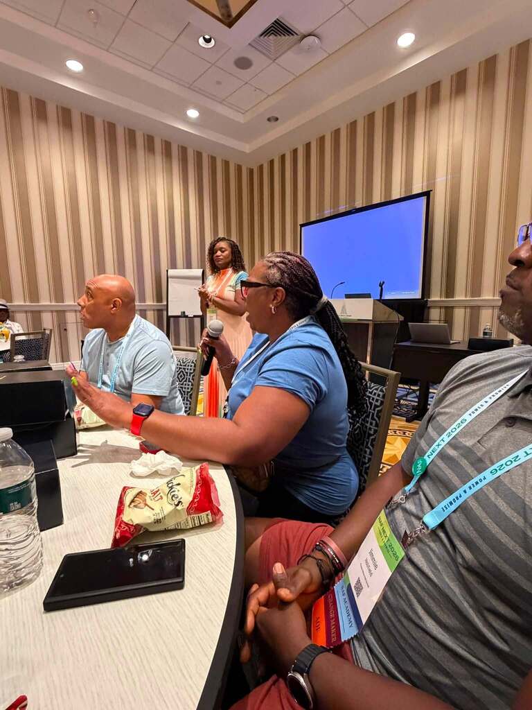 A woman speaks into a microphone during the 2026 NAF Next Conference.