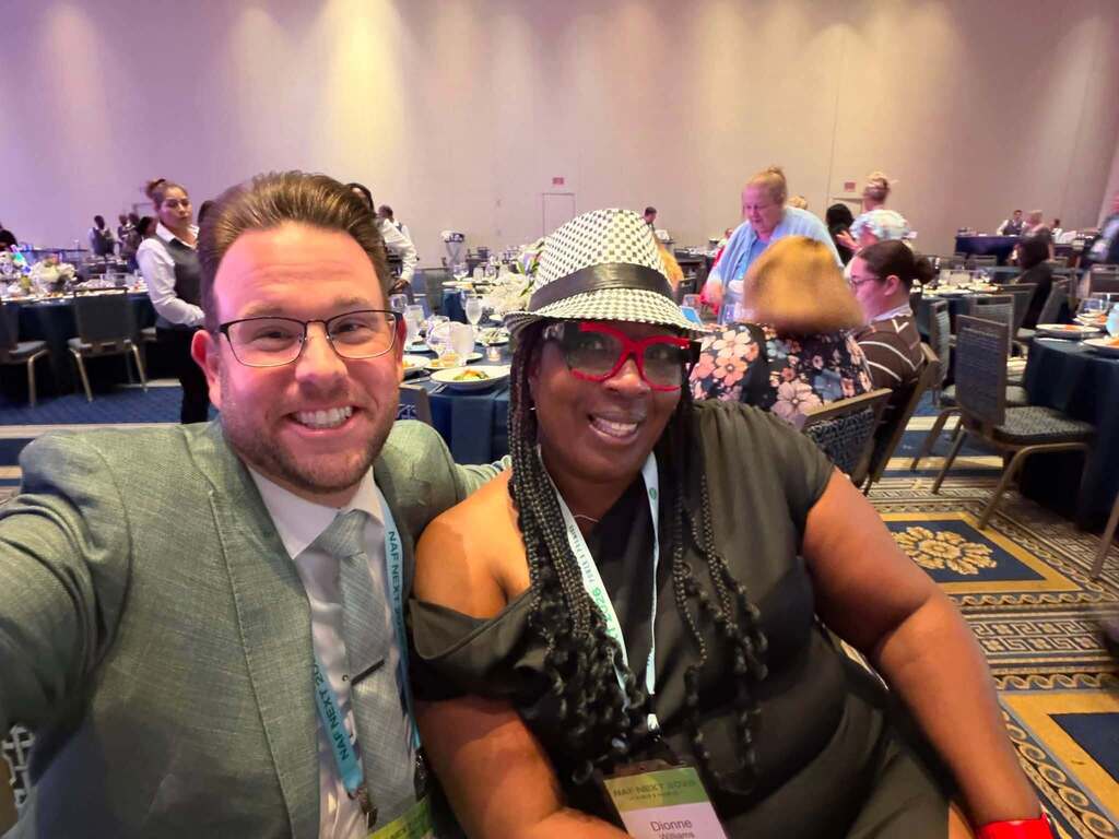 CTE Specialist Dr. Christopher Shaw and Center Point High School teacher Dionne Williams pose for a photo while sitting at a table at the NAF Conference.