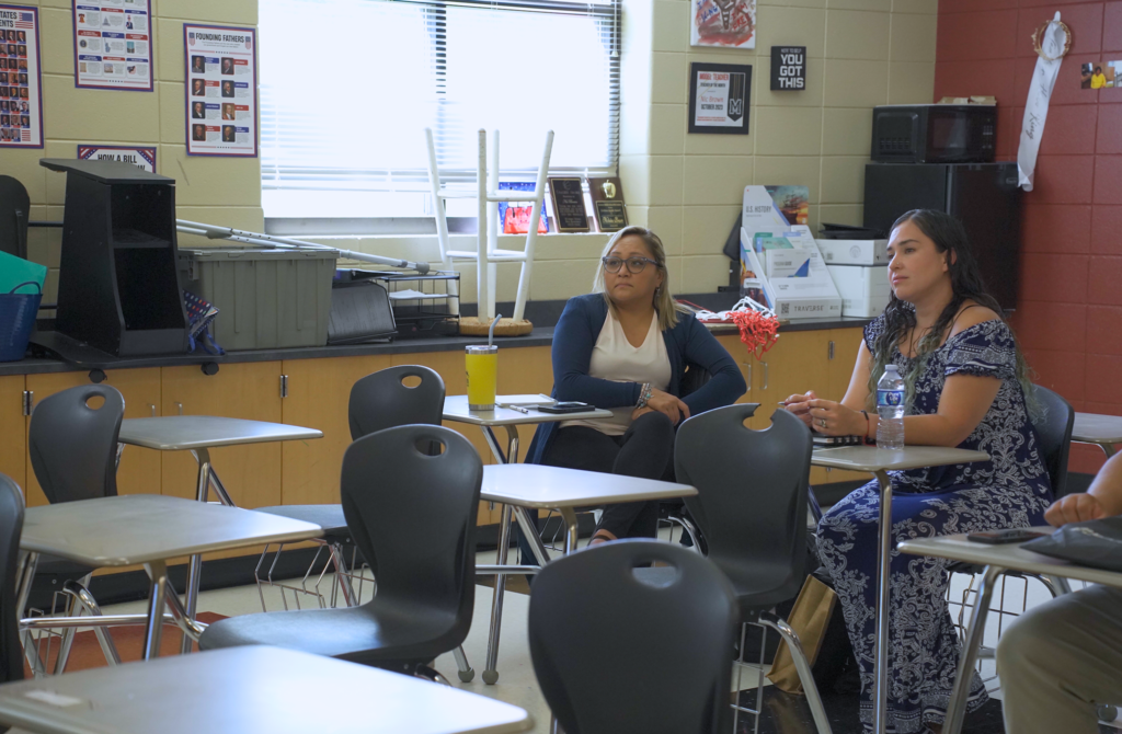 Educators sit in a classroom and listen to a presenter.