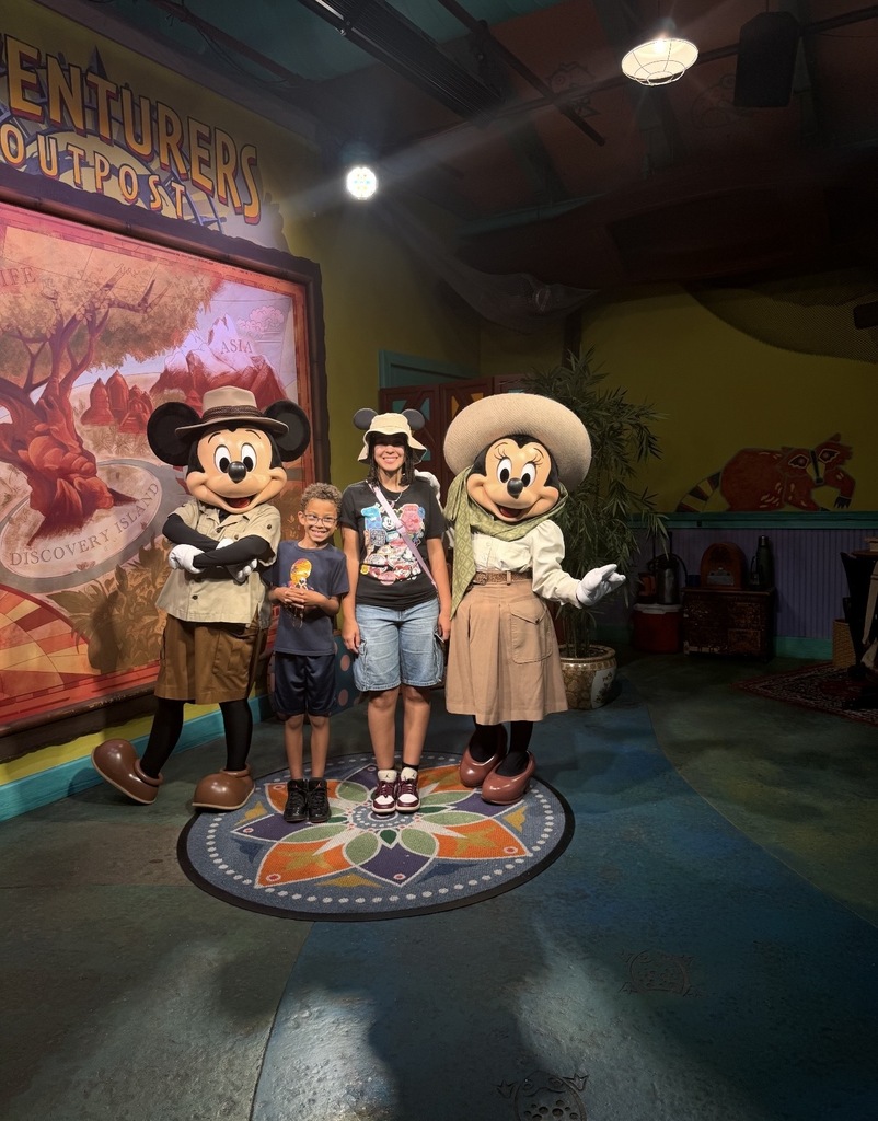 Two students stand together for a photo with Mickey and Minnie Mouse at Animal Kingdom.