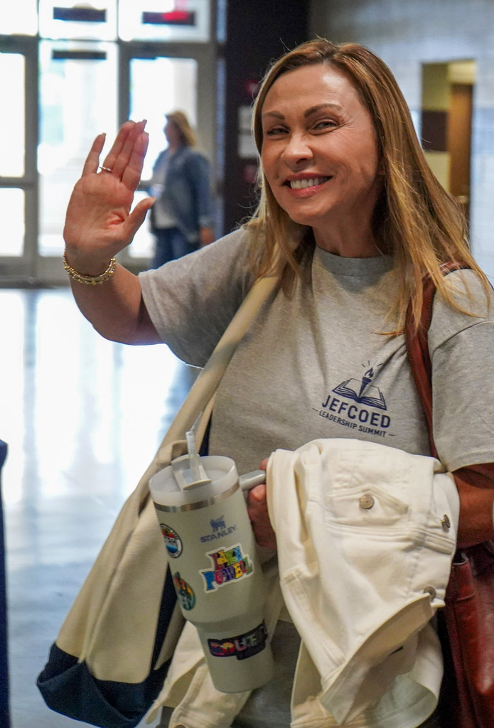 A woman smiles and waves at the camera as she walks into the 2026 JEFCOED Leadership Summit. 