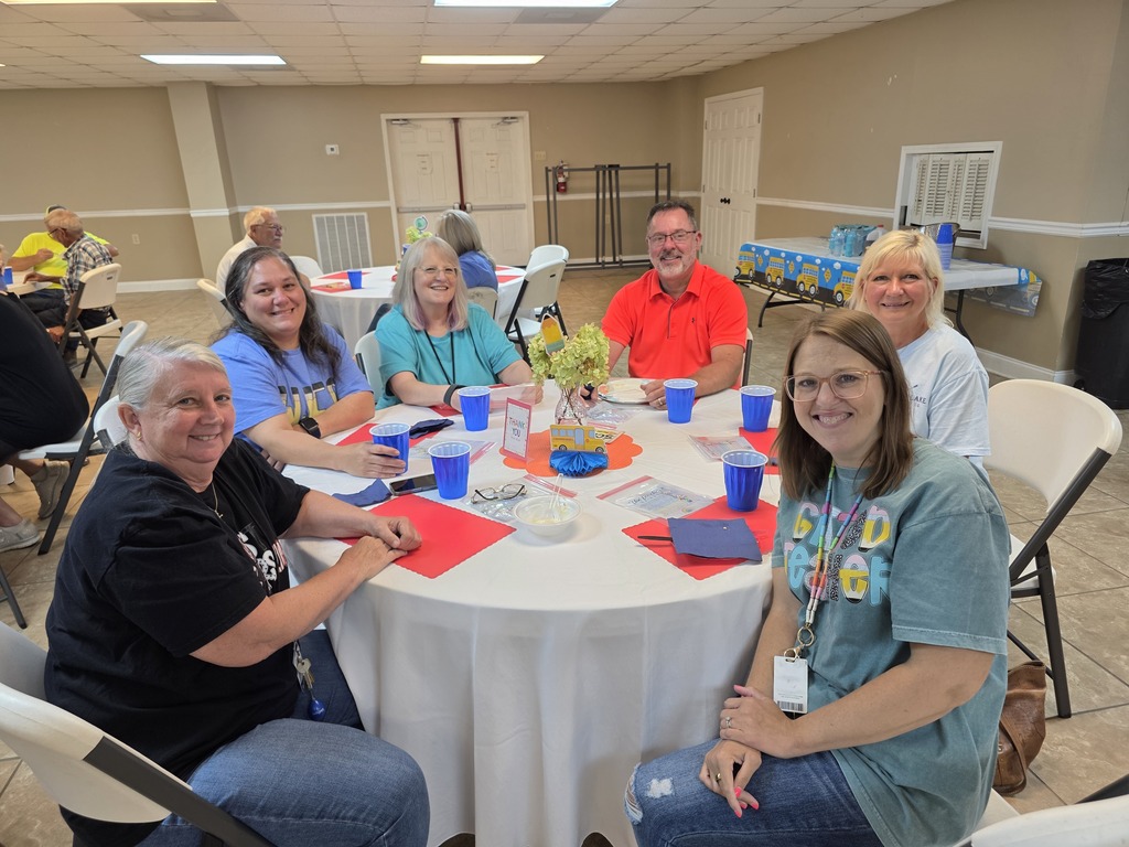 Music teacher, Office coordinator, 5th and 4th grade teachers, counselor, and gifted teacher sitting at a table