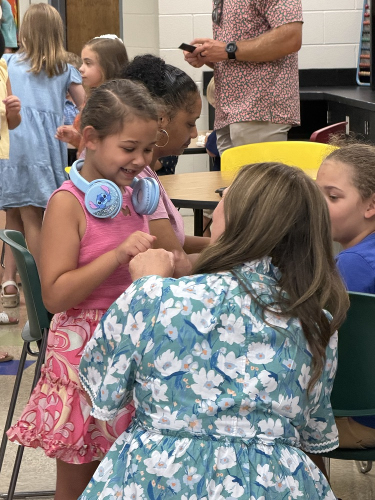 A teacher on a students level giving a fist bump