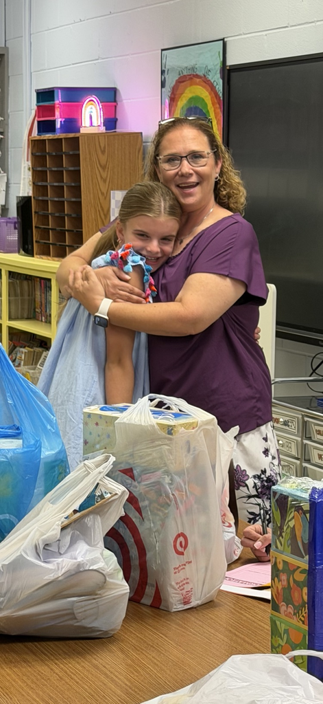 a teacher hugging a smiling child
