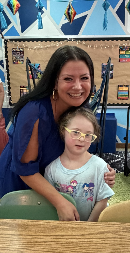a teacher and young girl posing for a picture