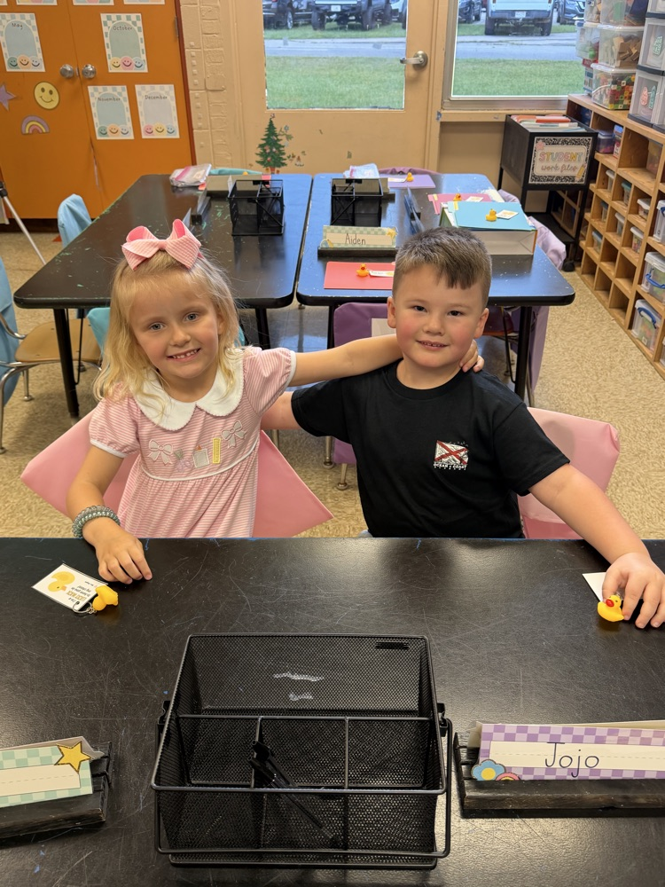 Two new kindergarten friends posing at their seats