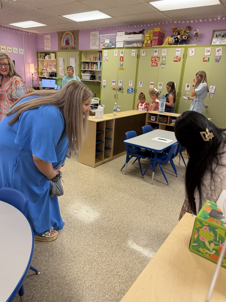 a teacher greeting a new student with a smile