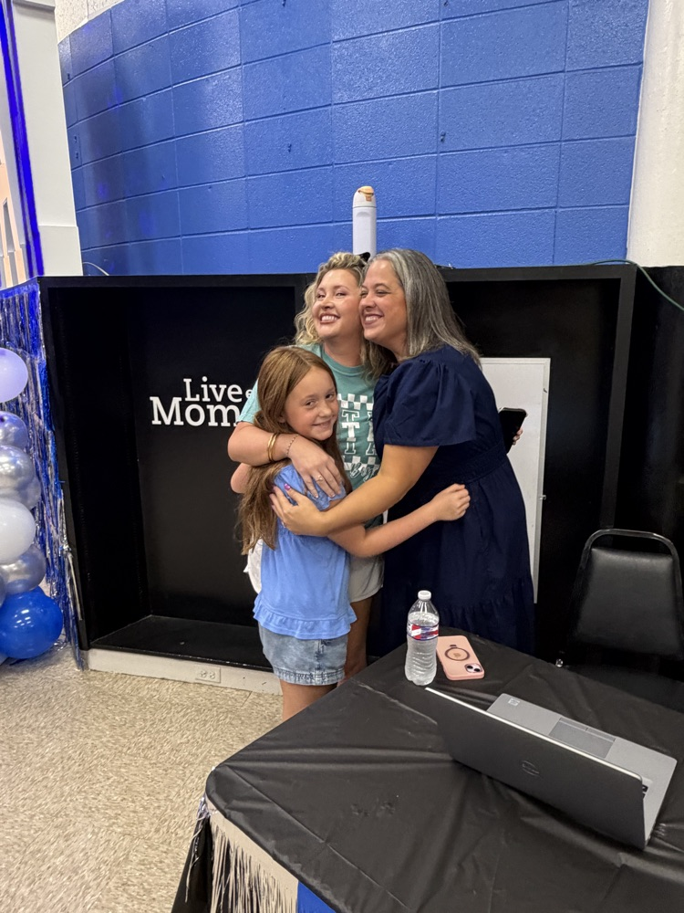 a group hug with the principal, a mom, and a student