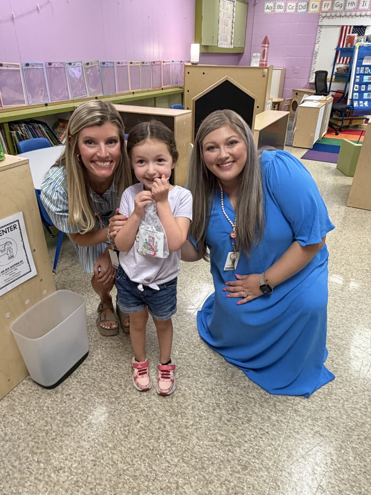 a PreK student posing with her new teachers