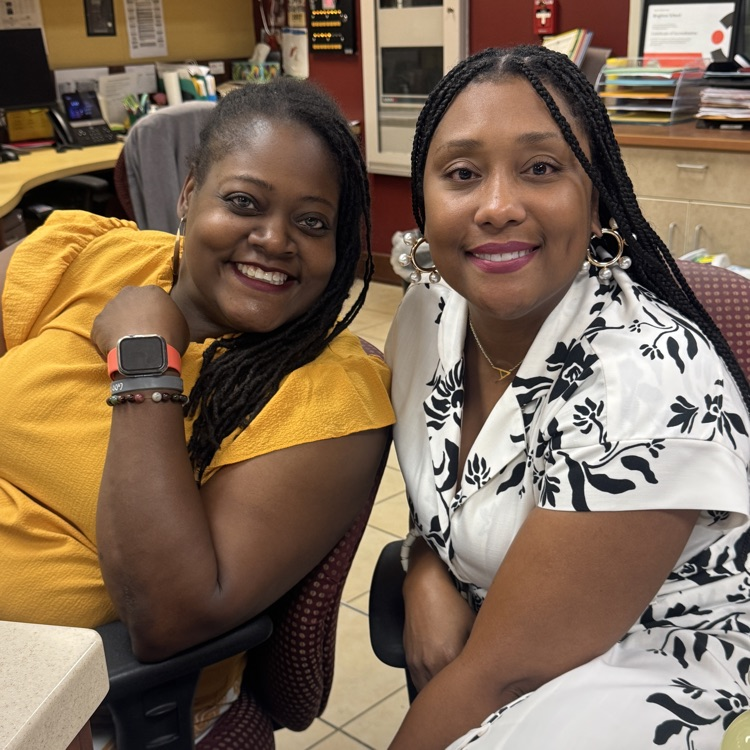 two principals sitting in an office and smiling