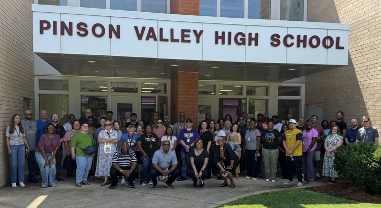 Group shot of faculty in front of school