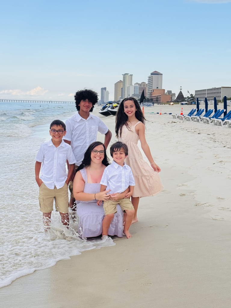 A family poses for a photo on a beach.
