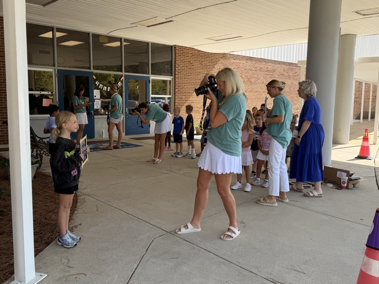 PTA ladies taking pictures of students for first day of school