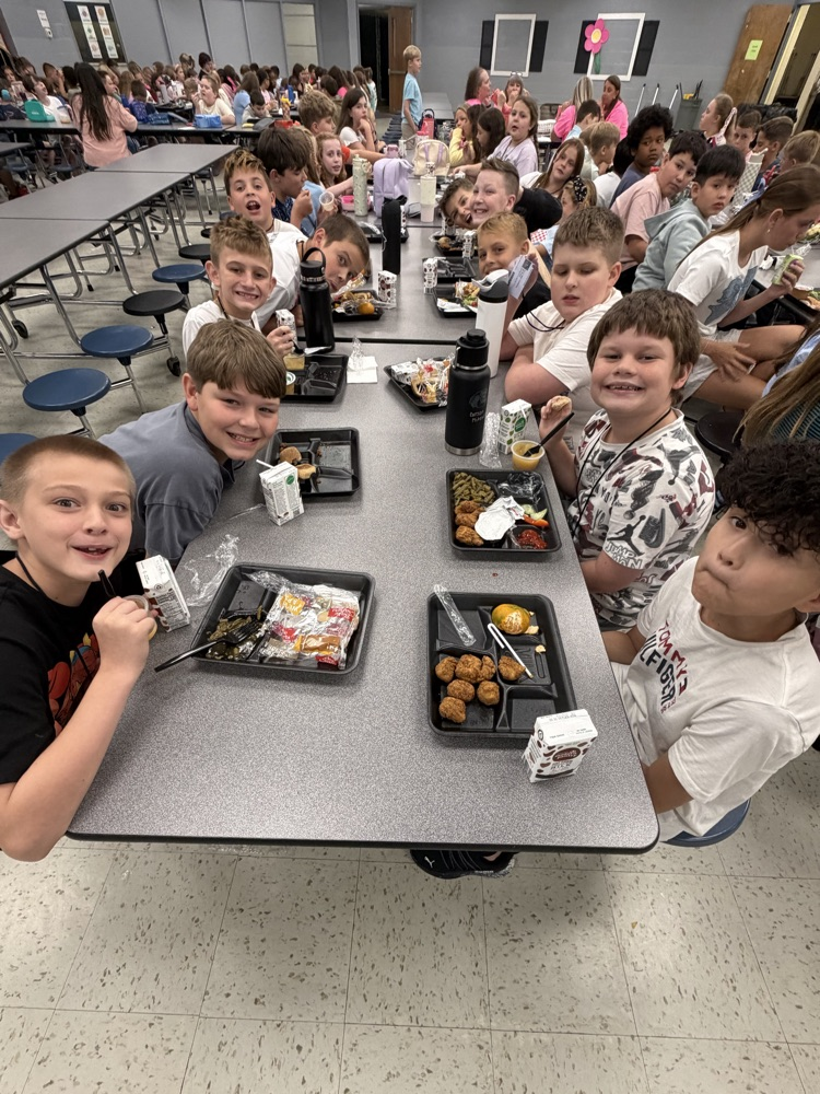 Students smiling at the lunch table