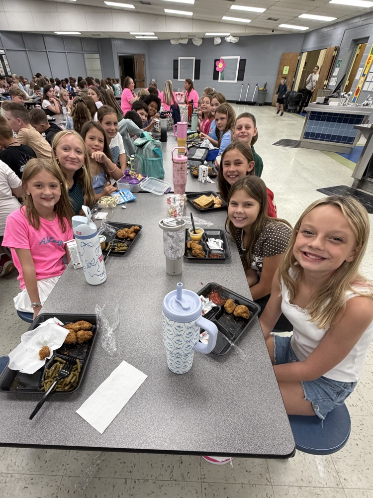 students smiling at the lunch table