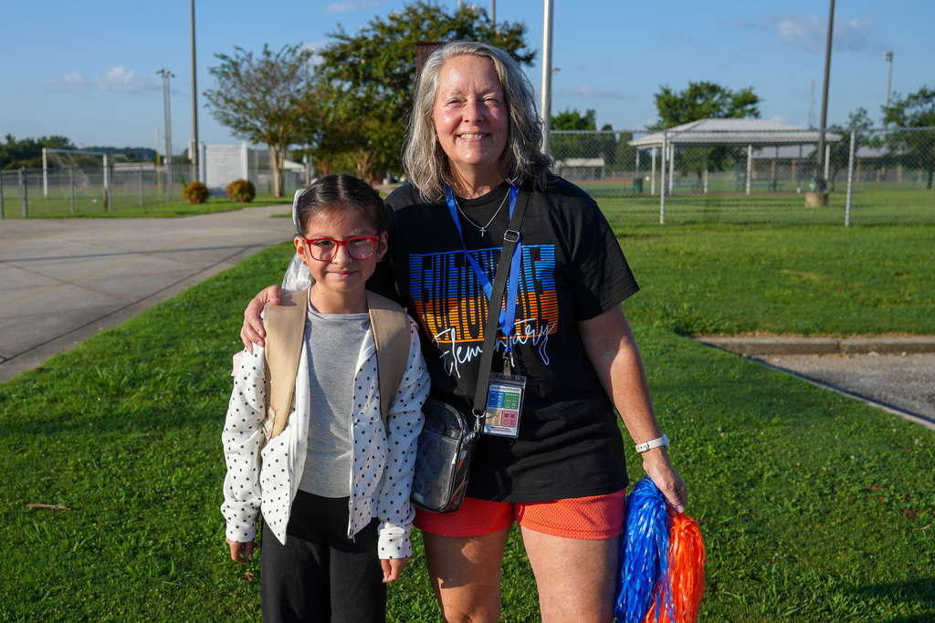 A Fultondale Elementary employee poses for a picture with a student on the first day of school.