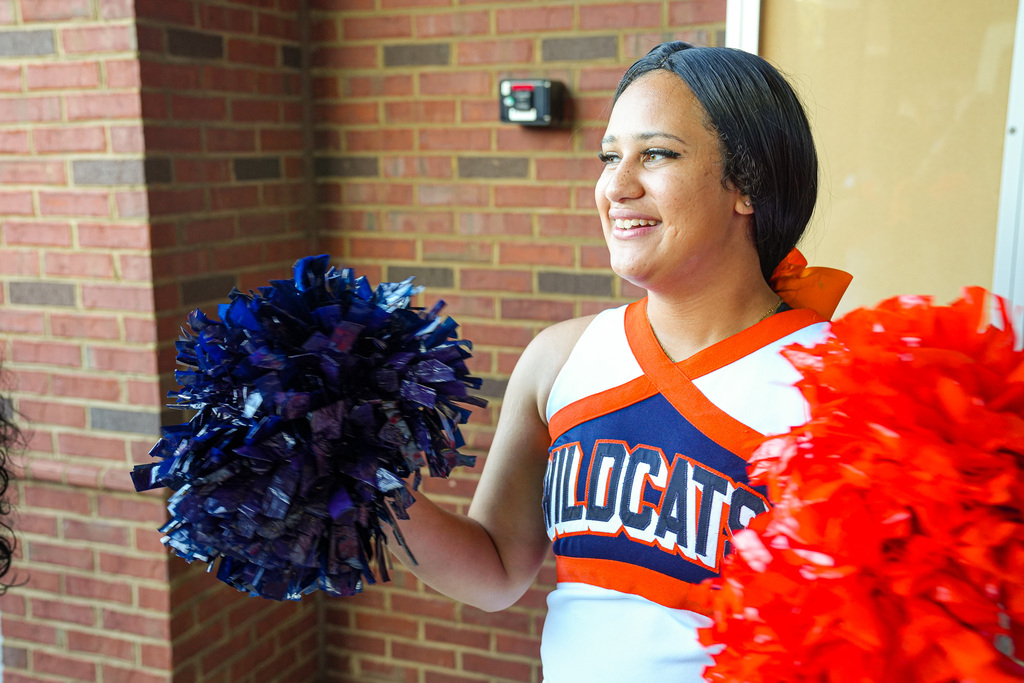 A Fultondale High School cheerleader waves pom poms as she welcomes students on the first day of school at Fultondale Elementary.