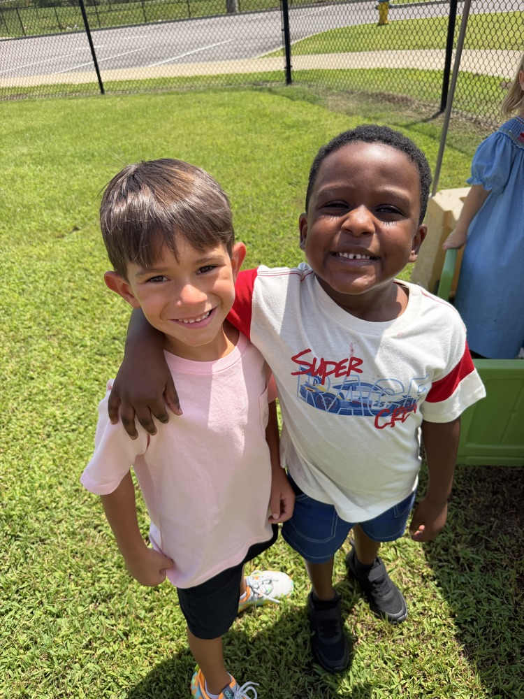 two boys posing for a picture together outside on the grass 