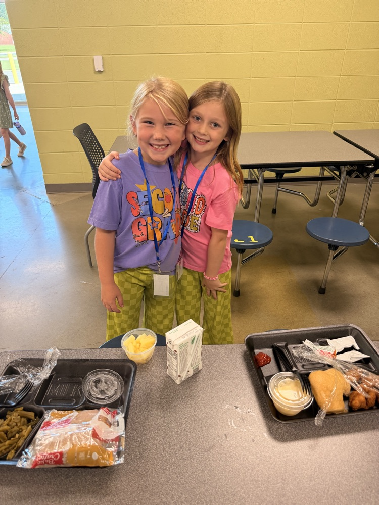 two girls posing together with matching pants in the lunchroom 