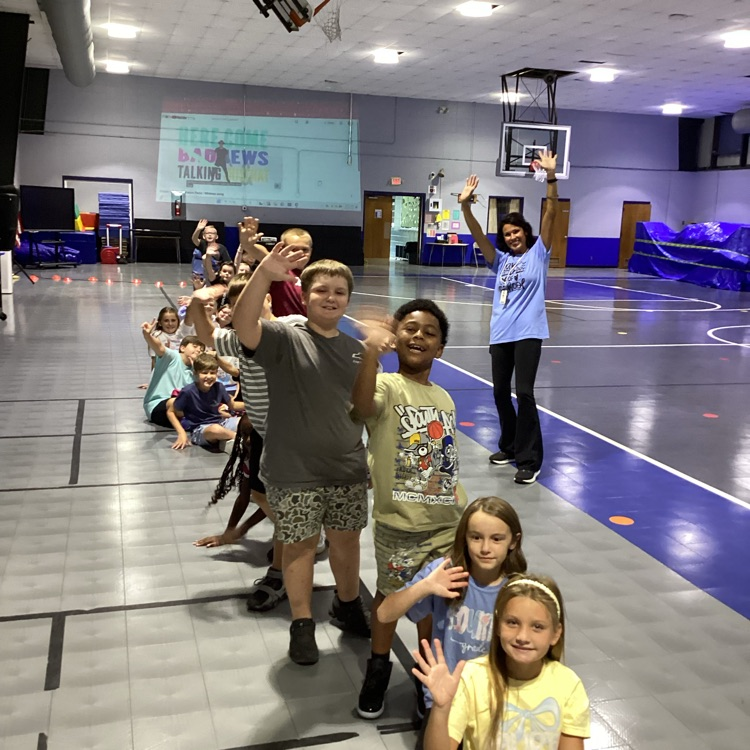 students at PE with teacher in gym 