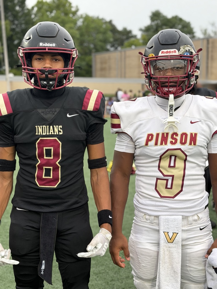 two PVHS football players stand in uniform
