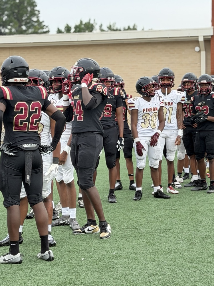 the football team lines up to the gate from the field house