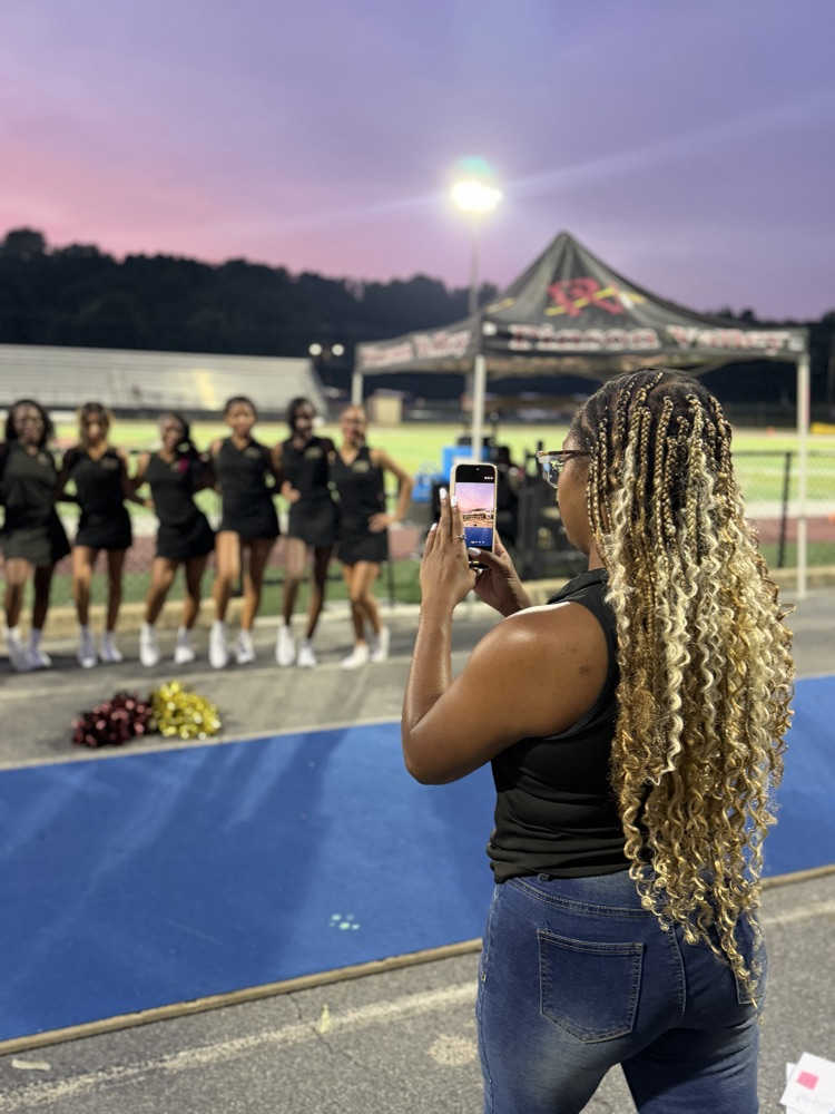 a cheer coach photographs the cheerleaders