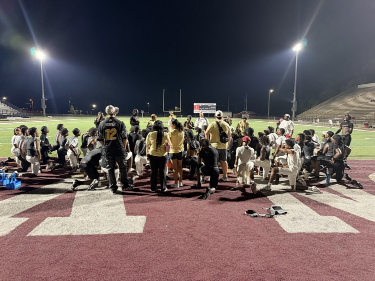 the football team huddles on the field