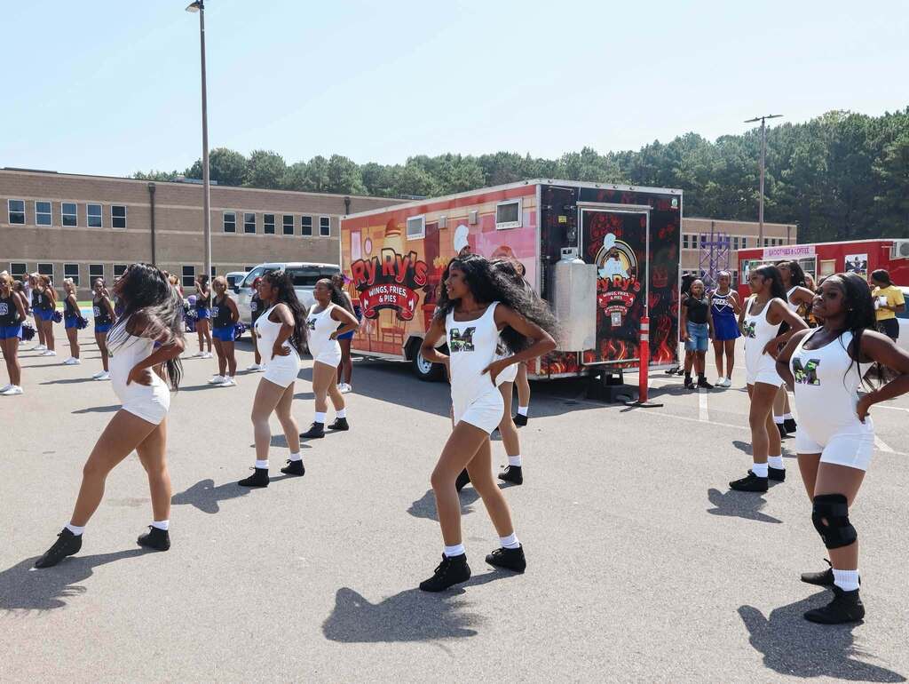 Members of a dance team perform outdoors.