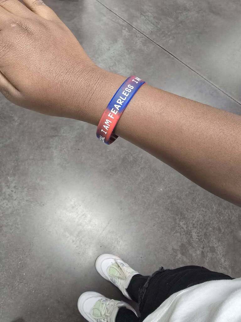 A person's hand showing off a bracelet that says "I am Fearless."