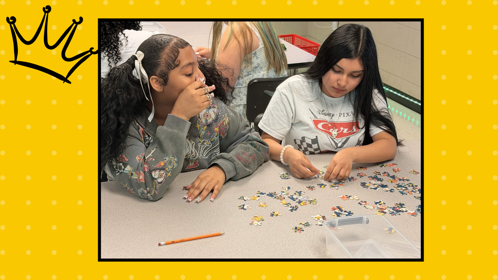 Two young ladies are working hard to complete a jigsaw puzzle.