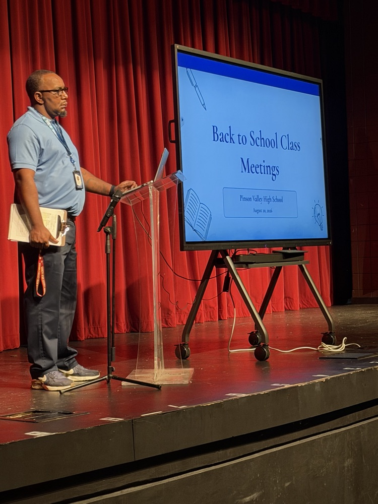 an administrator presents information from the stage
