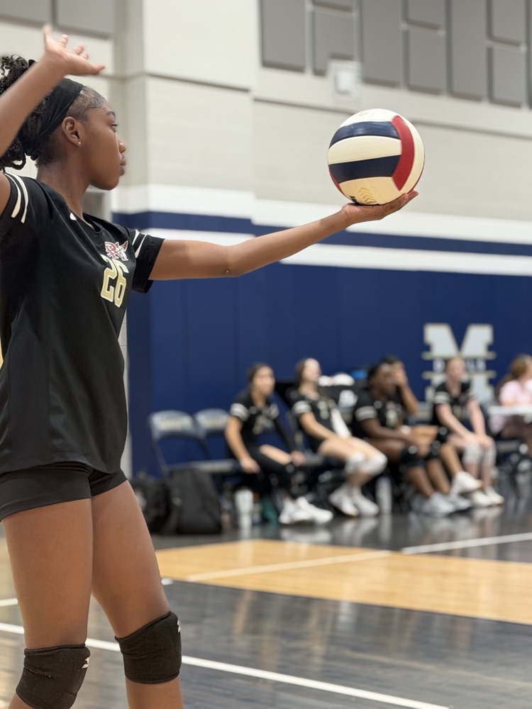a volleyball player lines up a serve