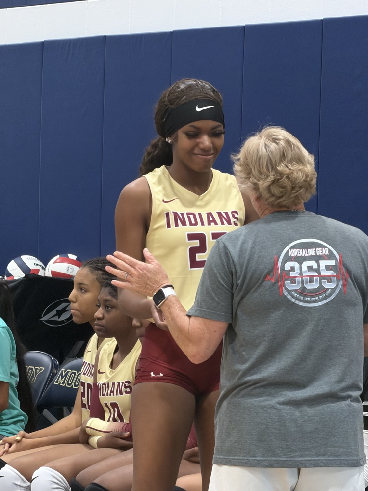 a volleball player high fives a coach