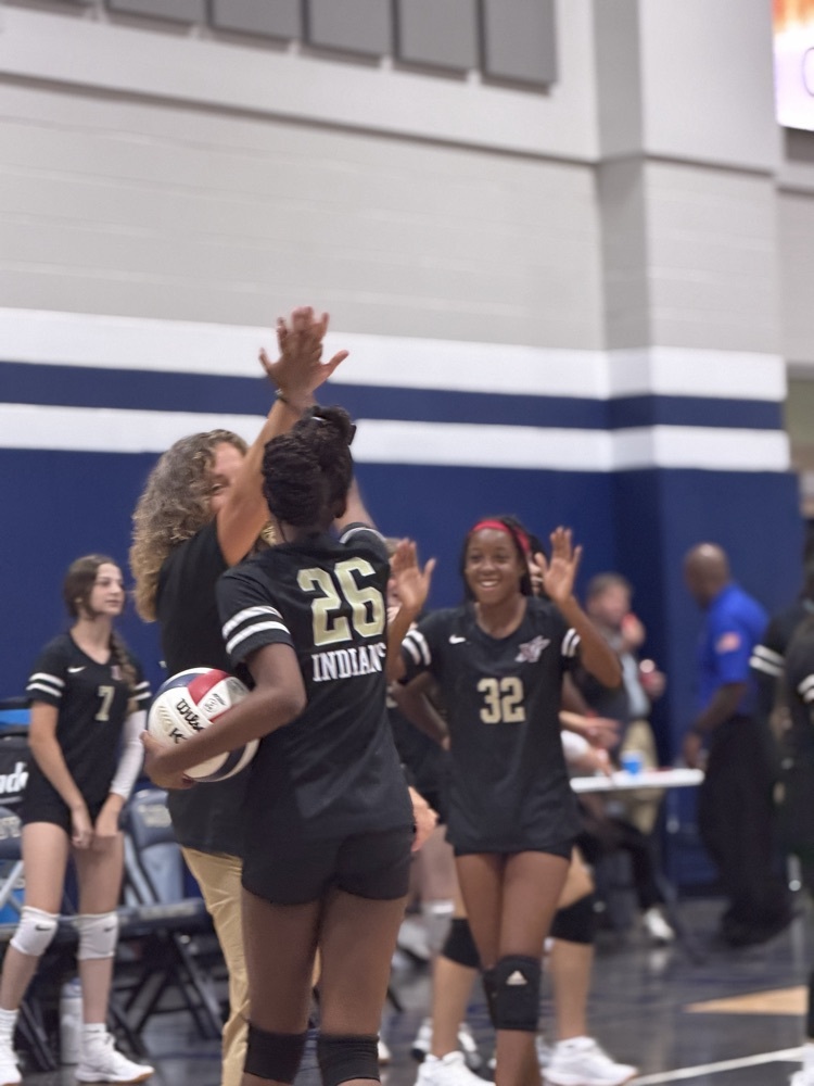 a volleball player high fives a coach