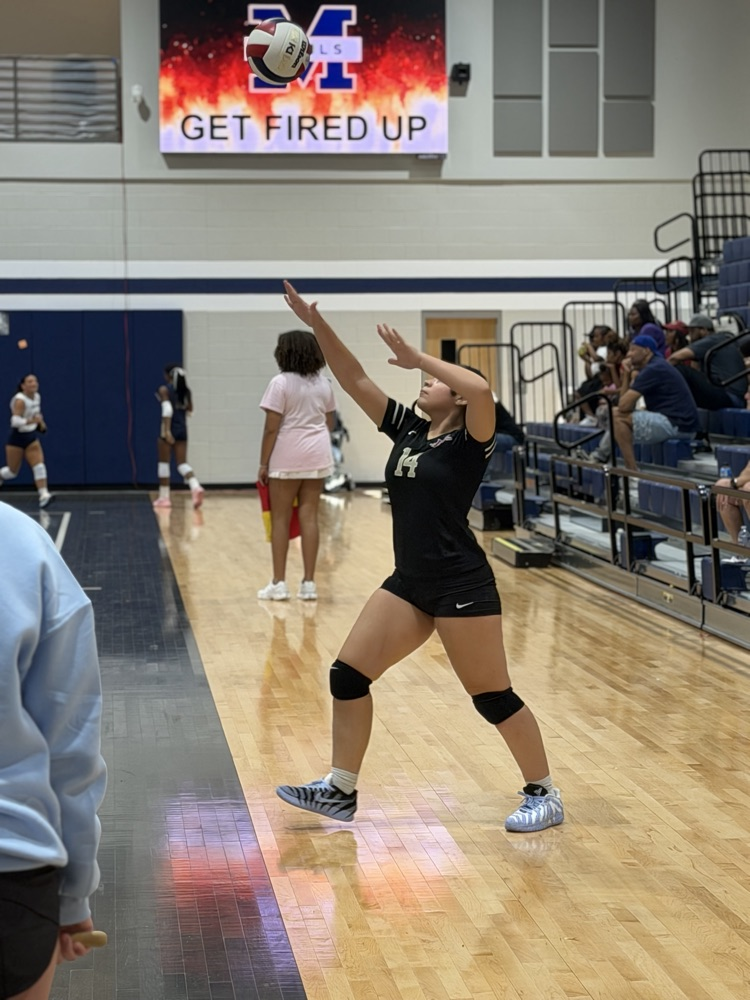 a volleyball player lines up a serve