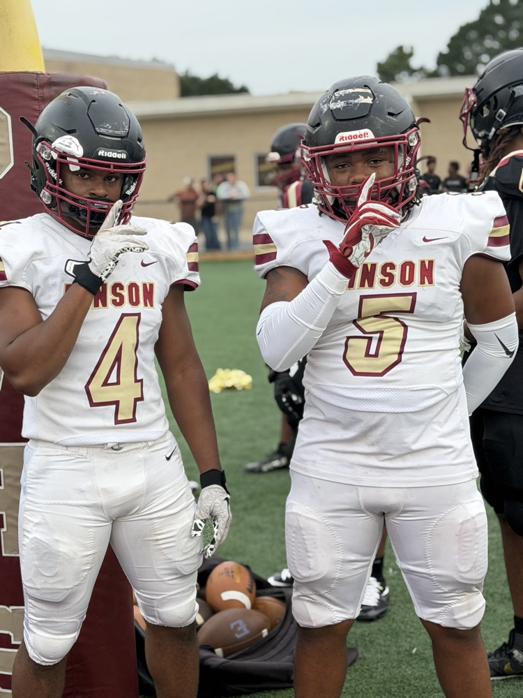 two players stand facing the camera making a shushing gesture over their face masks