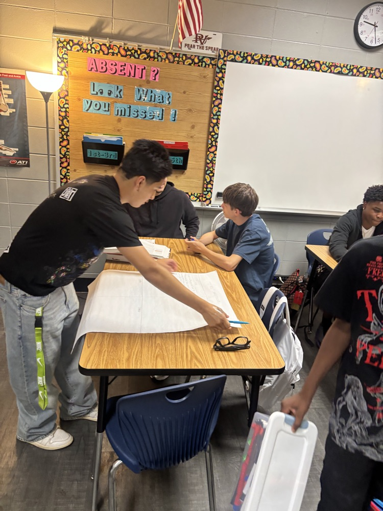 students work in groups to create posters 