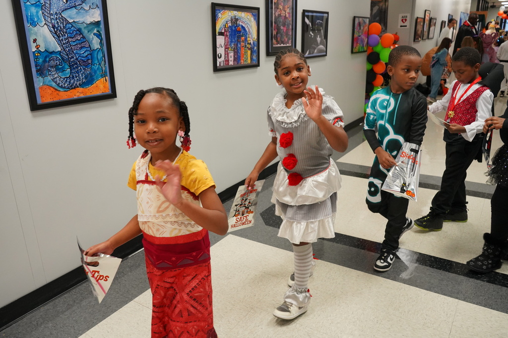 Students waving at the camera dressed in halloween costumes